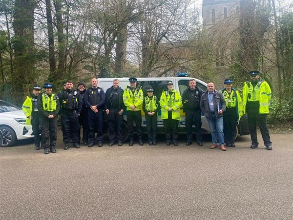 group of police officers stood in front of van