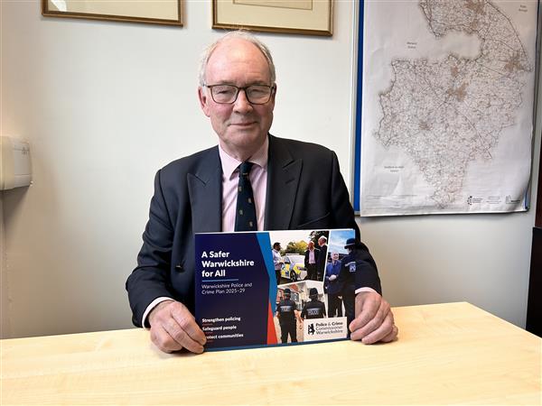 Philip Seccombe holds up a copy of the Police and Crime Plan