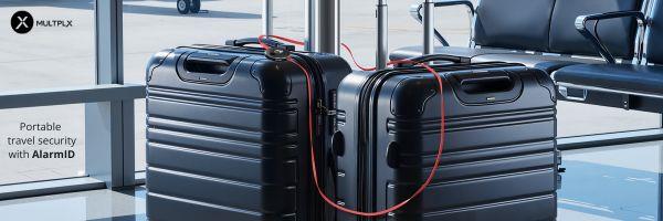 Image shows suitcases in an airport departure lounge locked with an AlarmID. They have a red wire around them and the alarm.