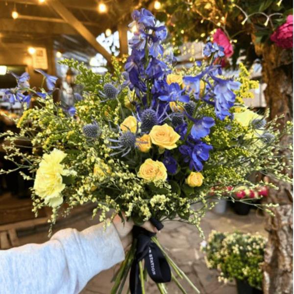 Image shows a bouquet of blue and yellow flowers