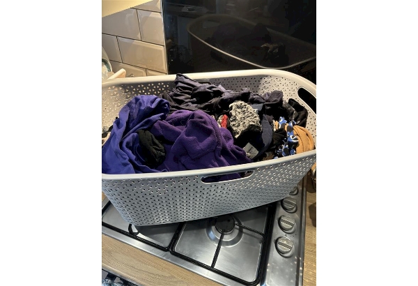 A gas hob being used as a temporary resting place for the laundry basket, a huge fire risk.