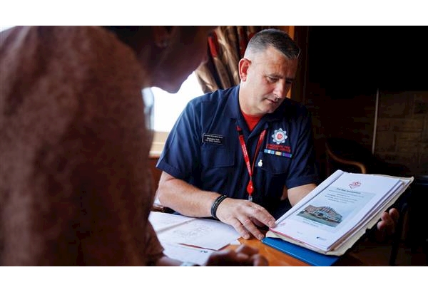 A Fire Safety Inspector sat with a business owner going through their fire risk assessment
