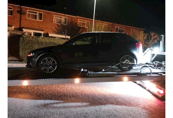 Seized vehicle on the back of a recovery truck.
