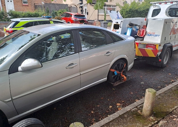 A car with a flat tire on the side of it

AI-generated content may be incorrect.