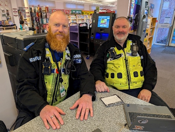 Two men in police uniforms sitting at a table
AI-generated content may be incorrect.