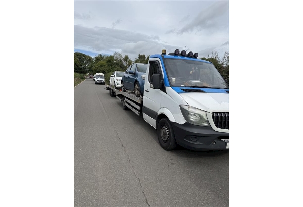 Picture of two vehicles seized on the back of a recovery truck