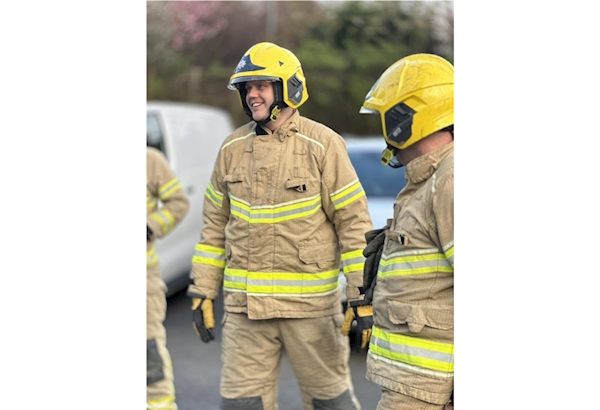 An on-call firefighter smiling whilst taking part in a drill activity